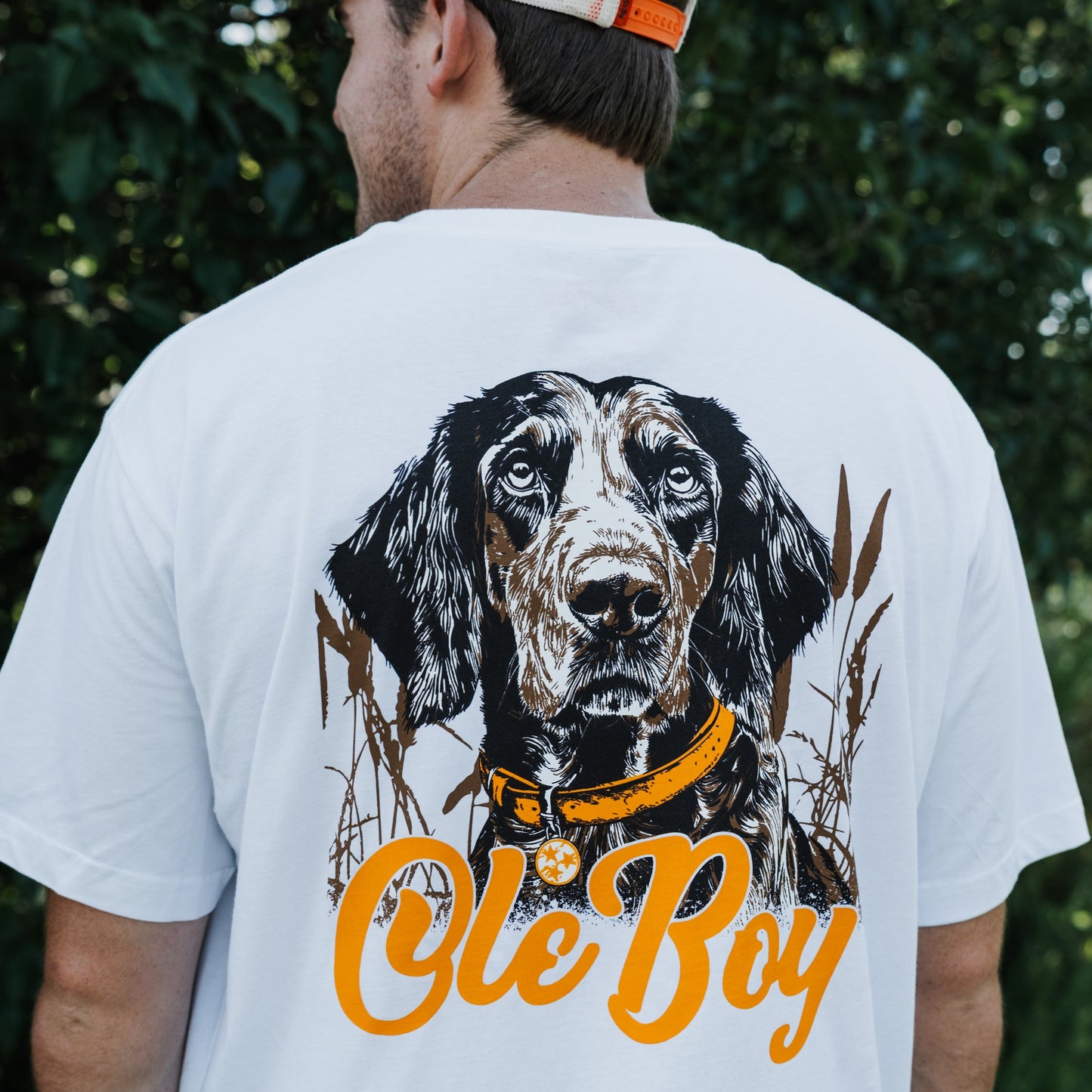Person wearing a white t-shirt with a coonhound dog graphic and 'Ole Boy' text.