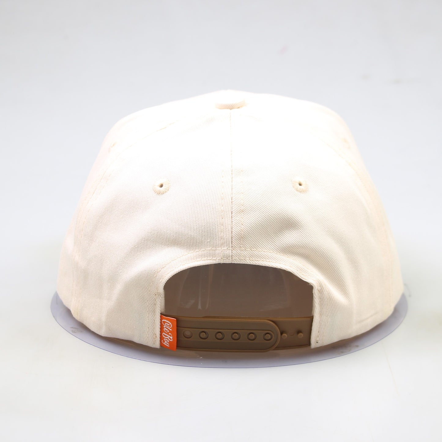 Beige cap with a brown patch on a white background