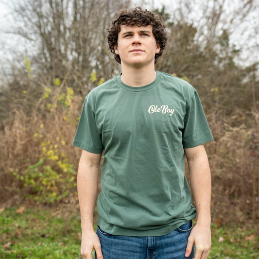 Person wearing a green t-shirt with 'Ole Boy' logo outdoors