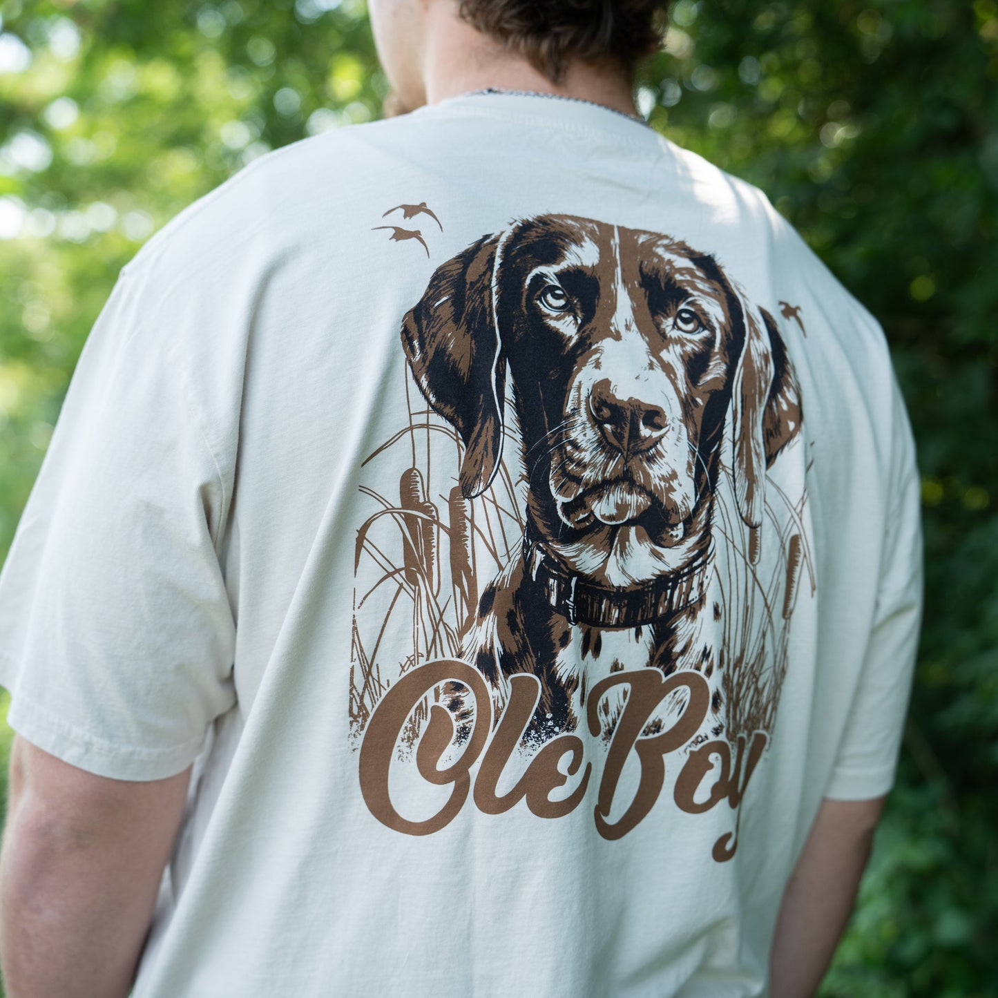 Person wearing a t-shirt with a GSP dog graphic and 'Ole Boy' text against a green outdoor background