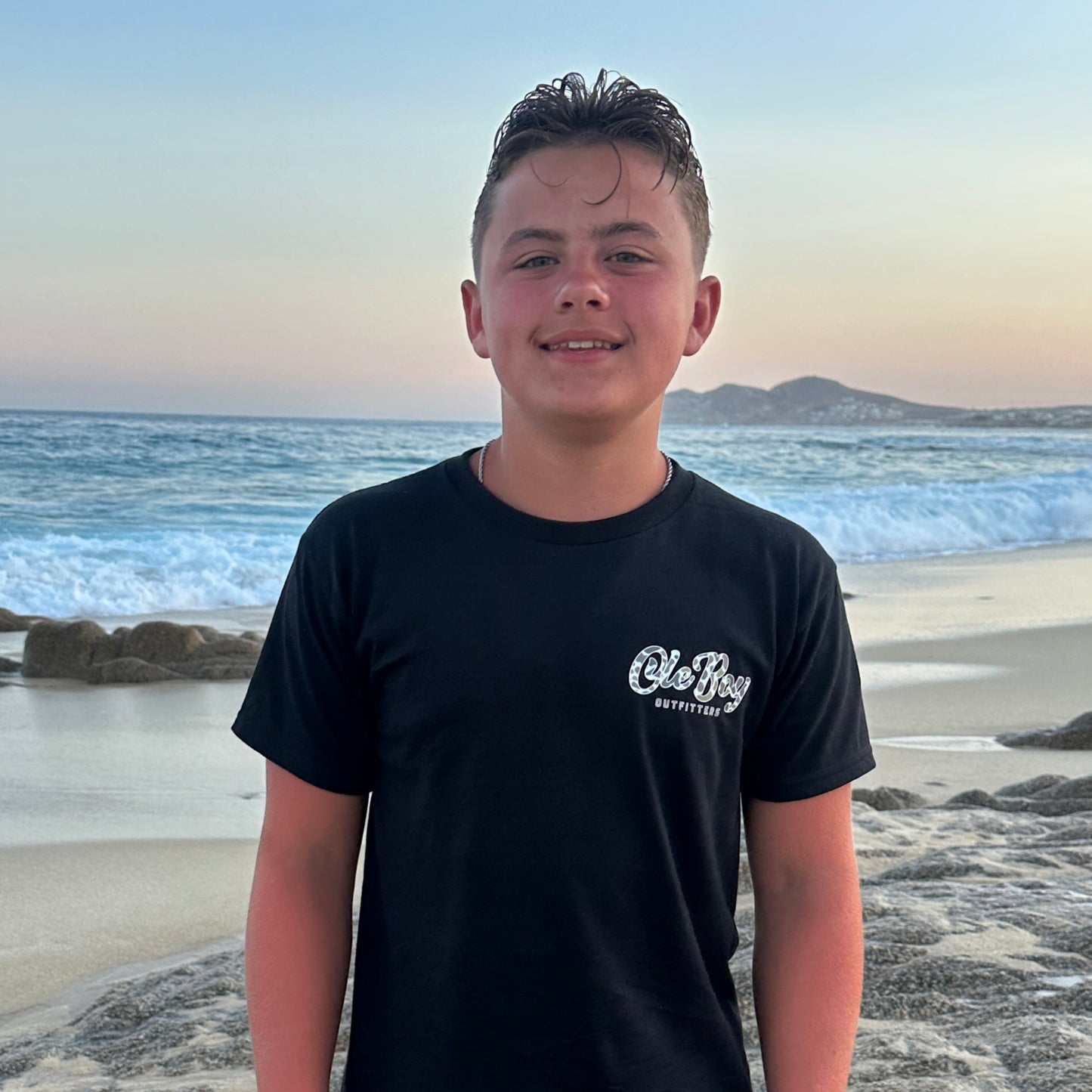 Person standing on a beach with ocean waves in the background