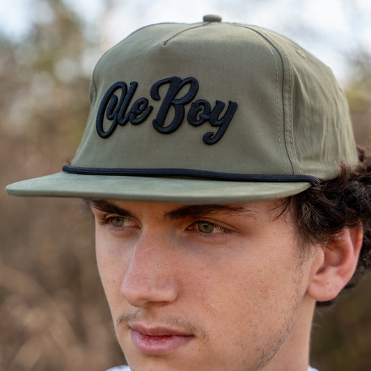 Person wearing a cap with 'Ole Boy' text outdoors