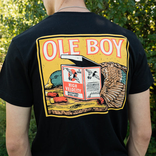 Person wearing a black t-shirt with a colorful graphic design on the back, featuring the text 'OLE BOY' and various graphics.