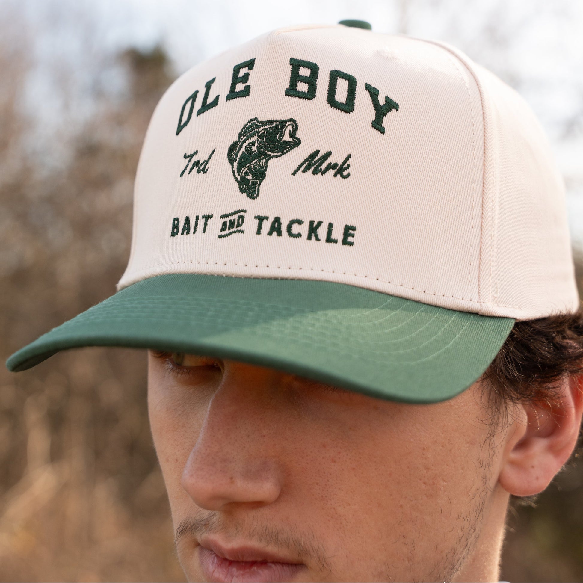 Man wearing a cap with 'Ole Boy Bait and Tackle' branding outdoors.