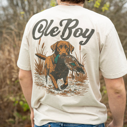 Person wearing a t-shirt with 'Ole Boy' and a dog graphic outdoors