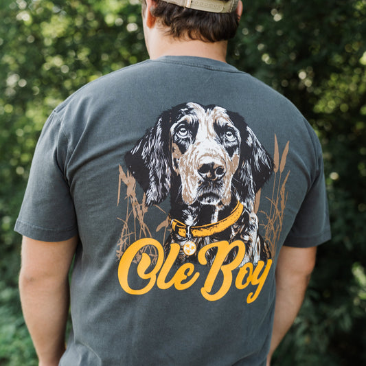 Person wearing a t-shirt with a coonhound dog graphic and 'Ole Boy' text outdoors.