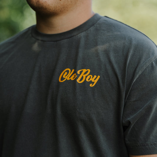 Person wearing a dark gray t-shirt with 'Ole Boy' printed in orange.