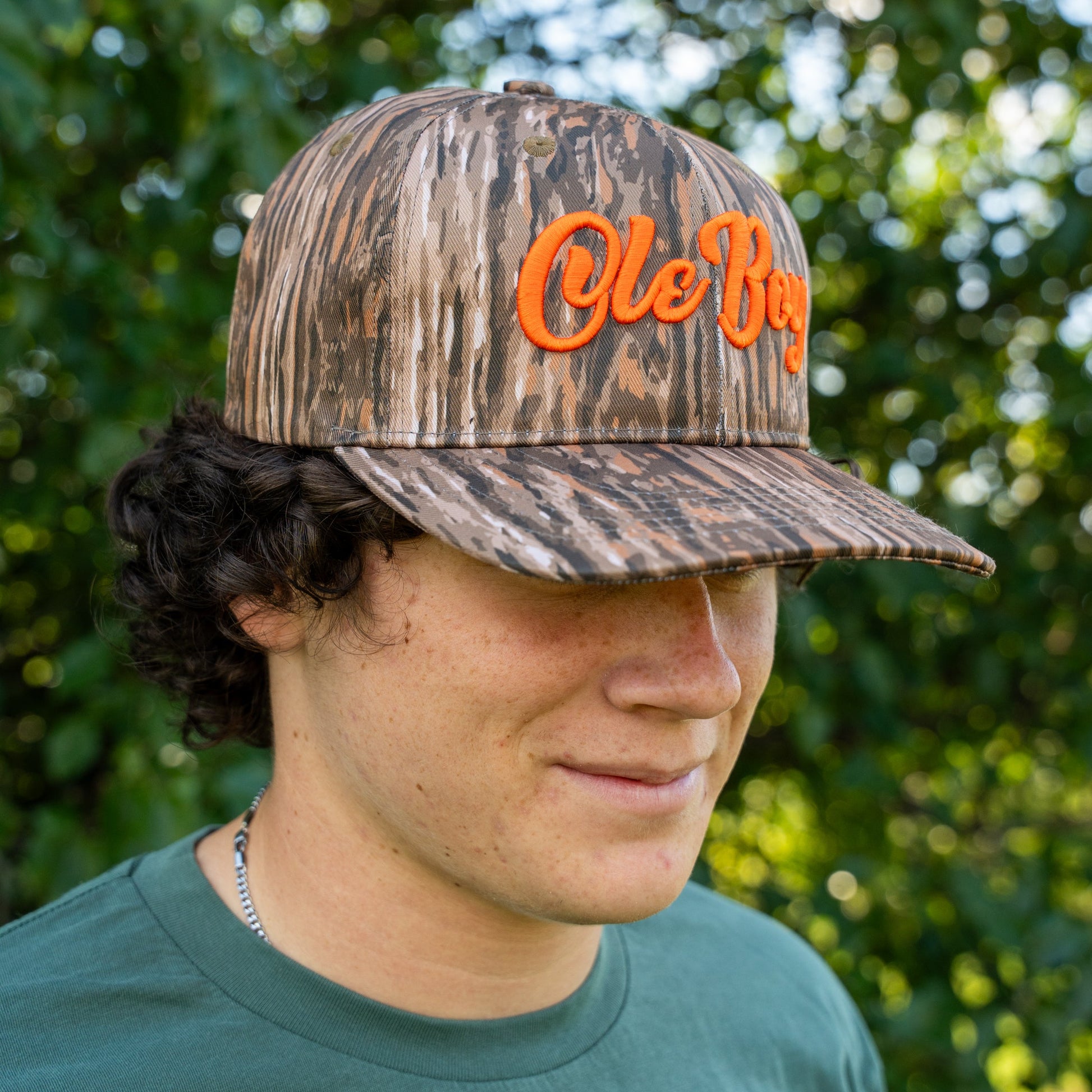 Person wearing a camouflage cap with 'Ole Boy' text outdoors