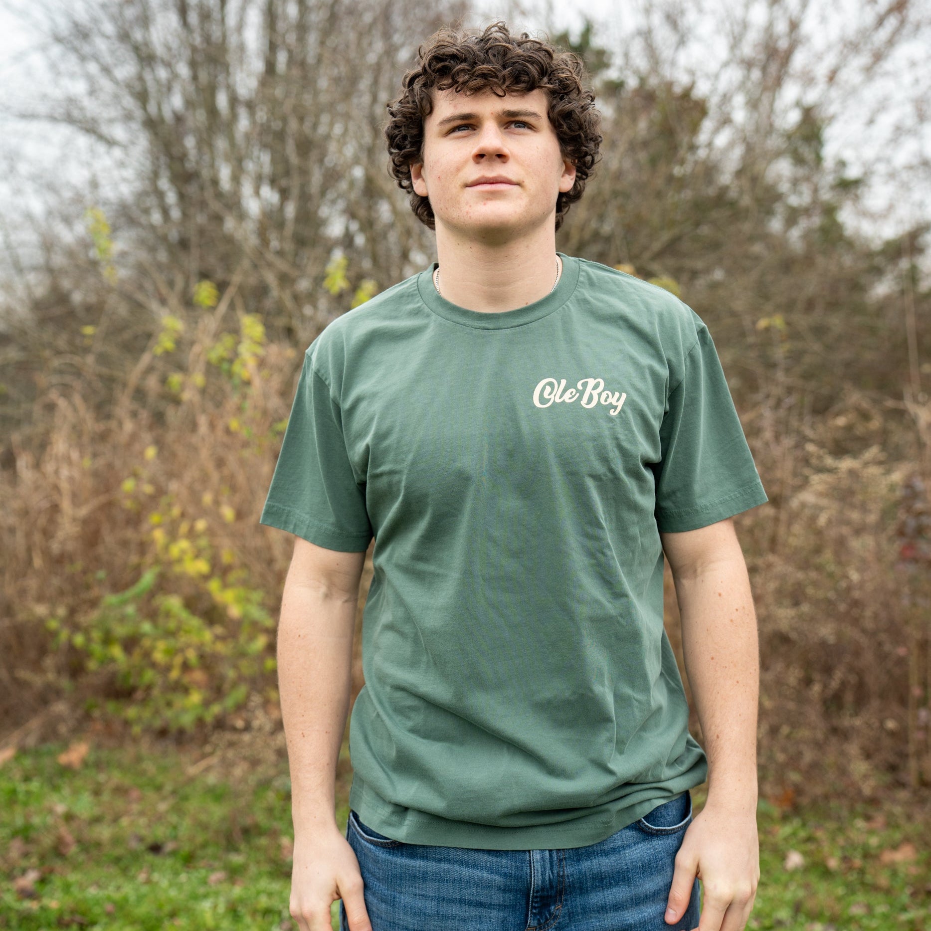 Person wearing a green t-shirt with 'Ole Boy' logo outdoors