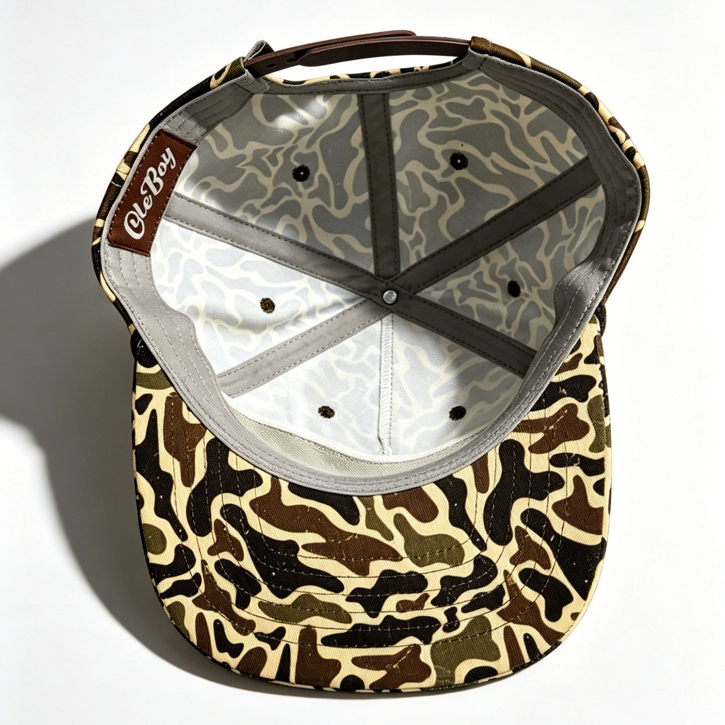 Camouflage-patterned cap with a brand logo on a white background