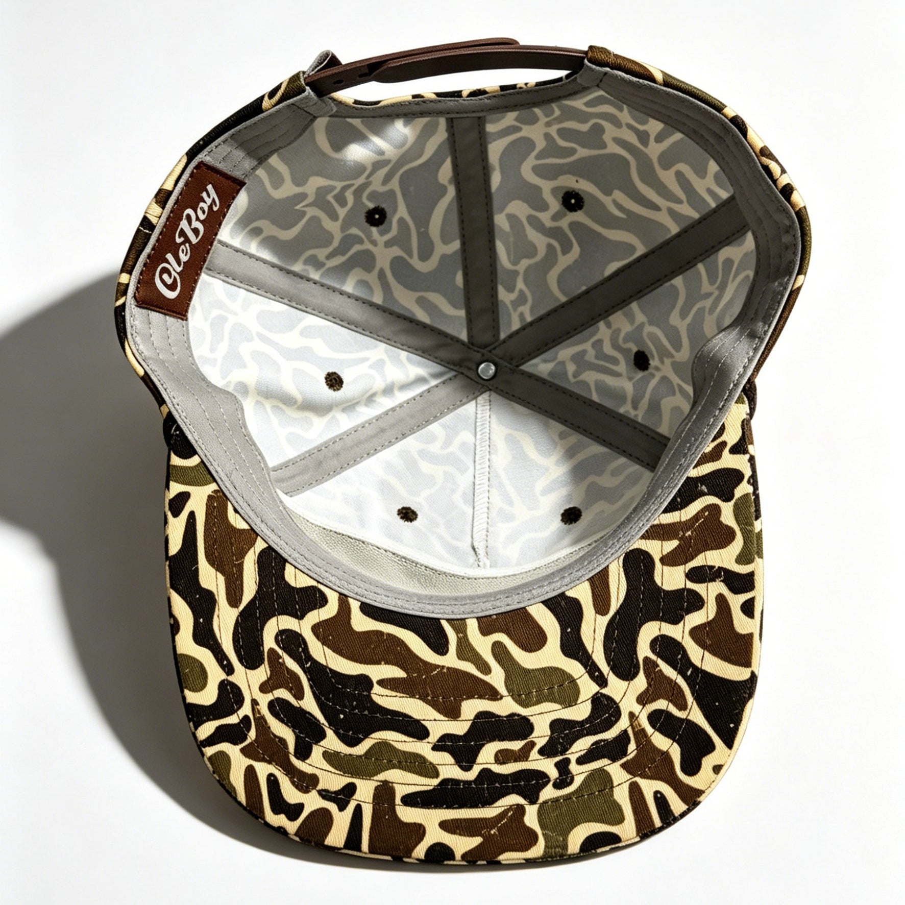 Camouflage-patterned cap with a brand logo on a white background