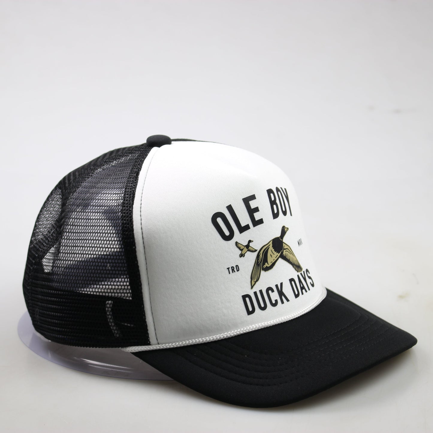 Black and white trucker hat with duck graphic and text on a light gray background
