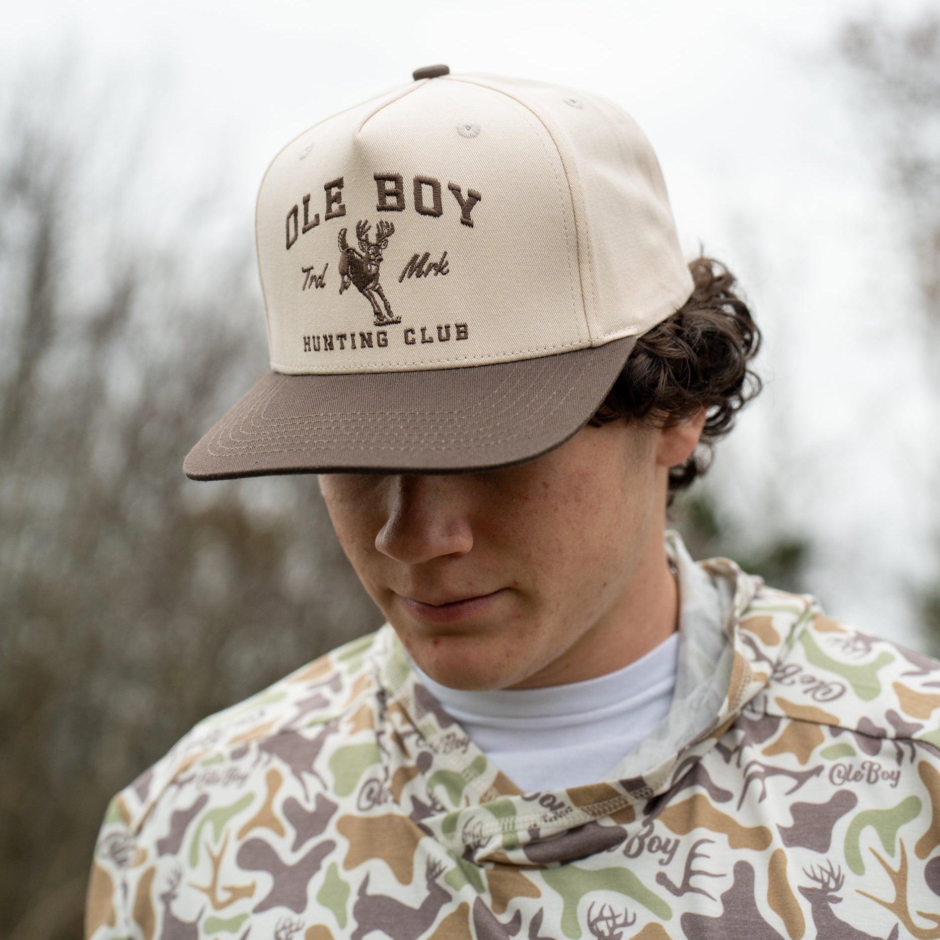 Person wearing a cap with 'Ole Boy' branding outdoors