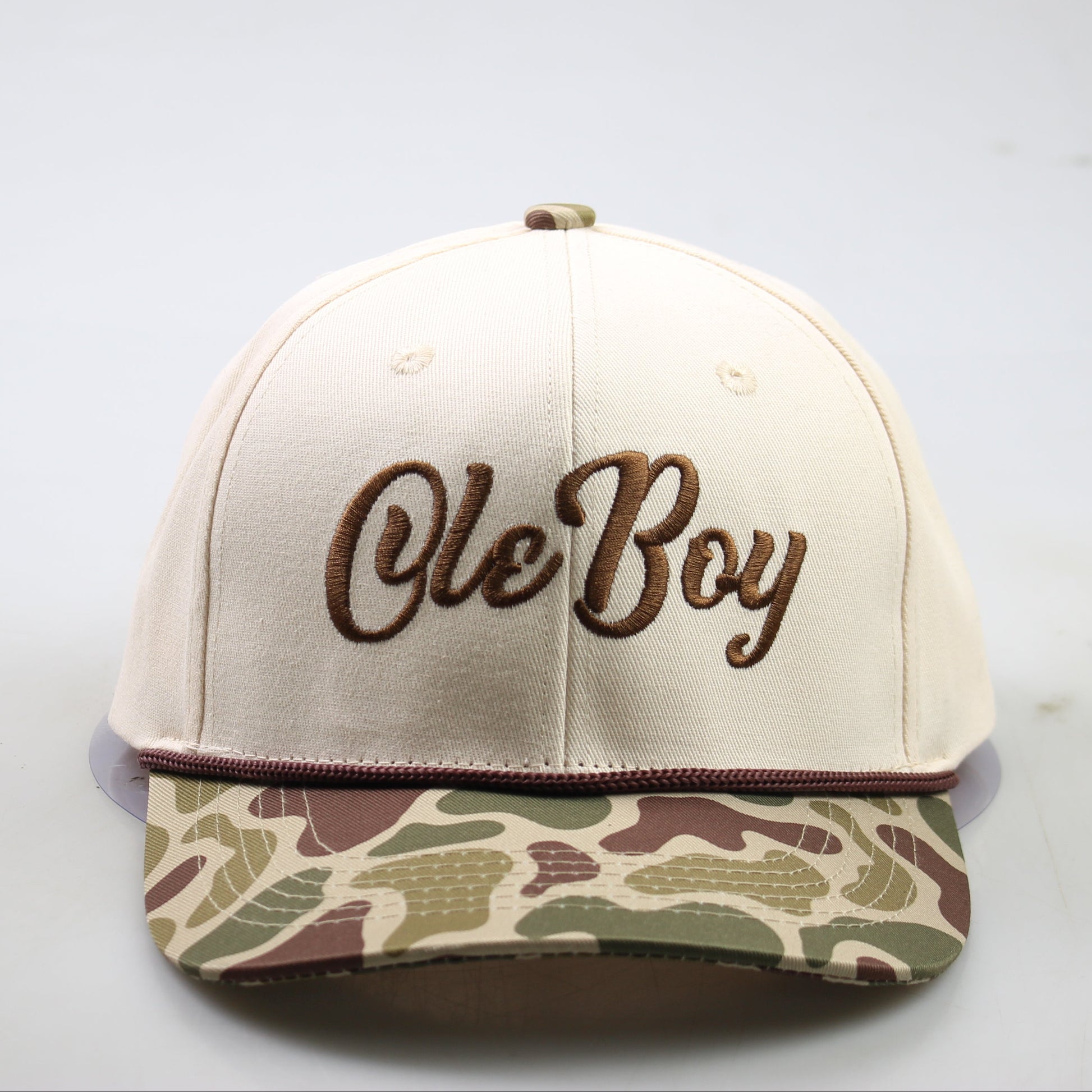 Beige cap with 'Ole Boy' text and camouflage visor on a light gray background