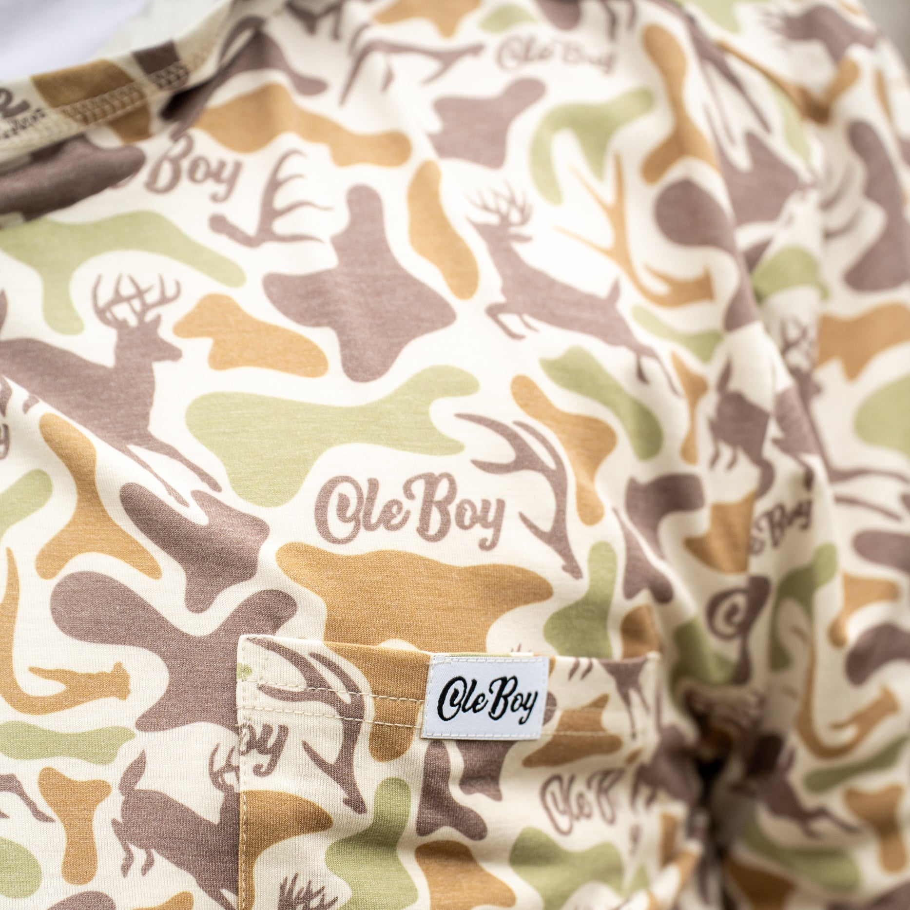 Camouflage-patterned fabric with 'ole Boy' branding