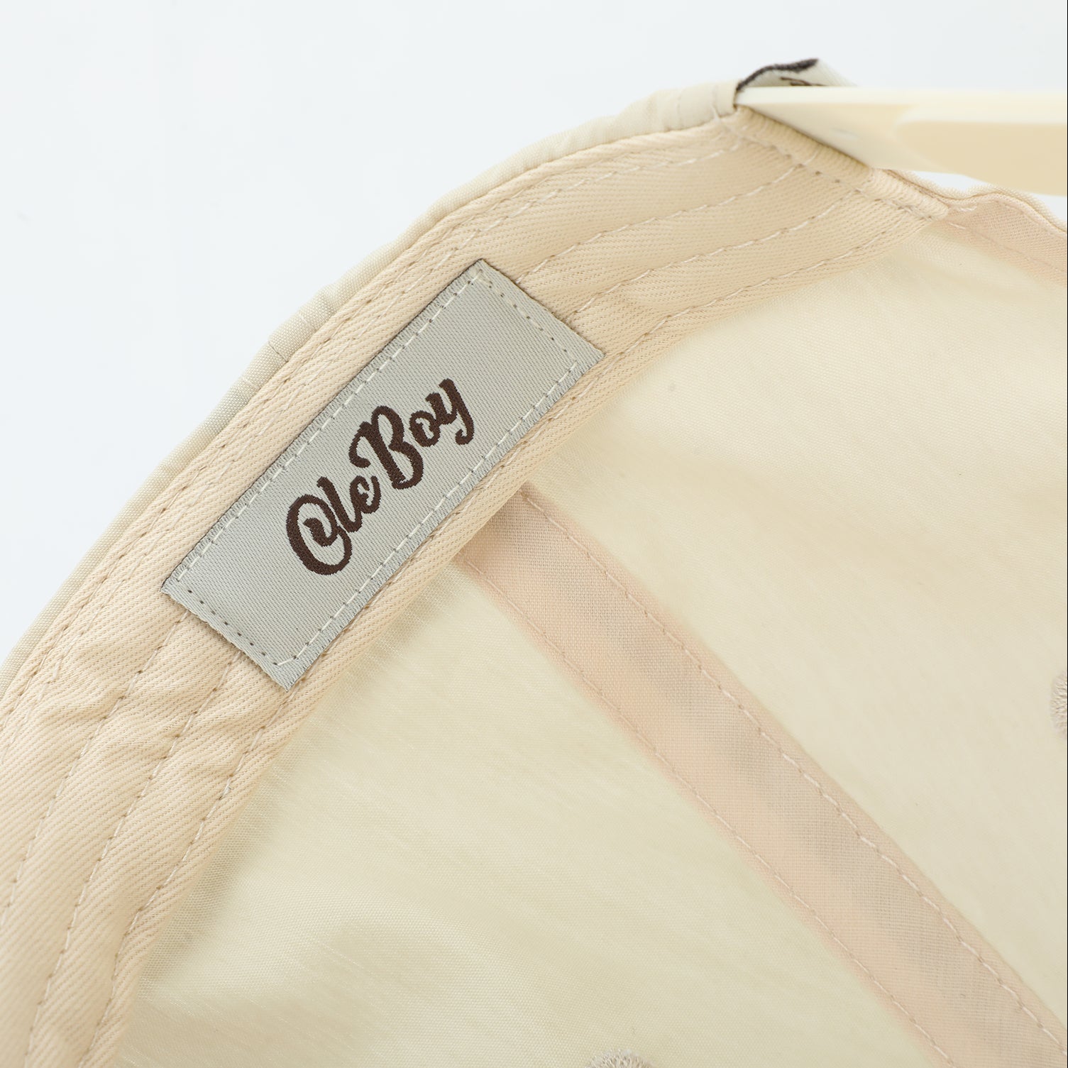 Beige cap with a 'Ole Boy' label on a light gray background