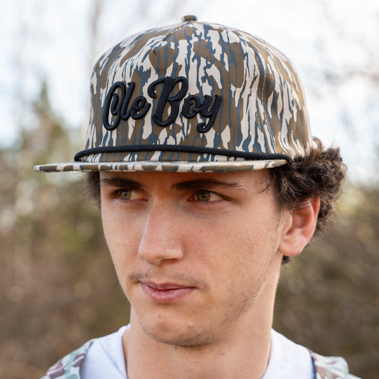 Person wearing a camouflage cap with 'Ole Boy' text outdoors