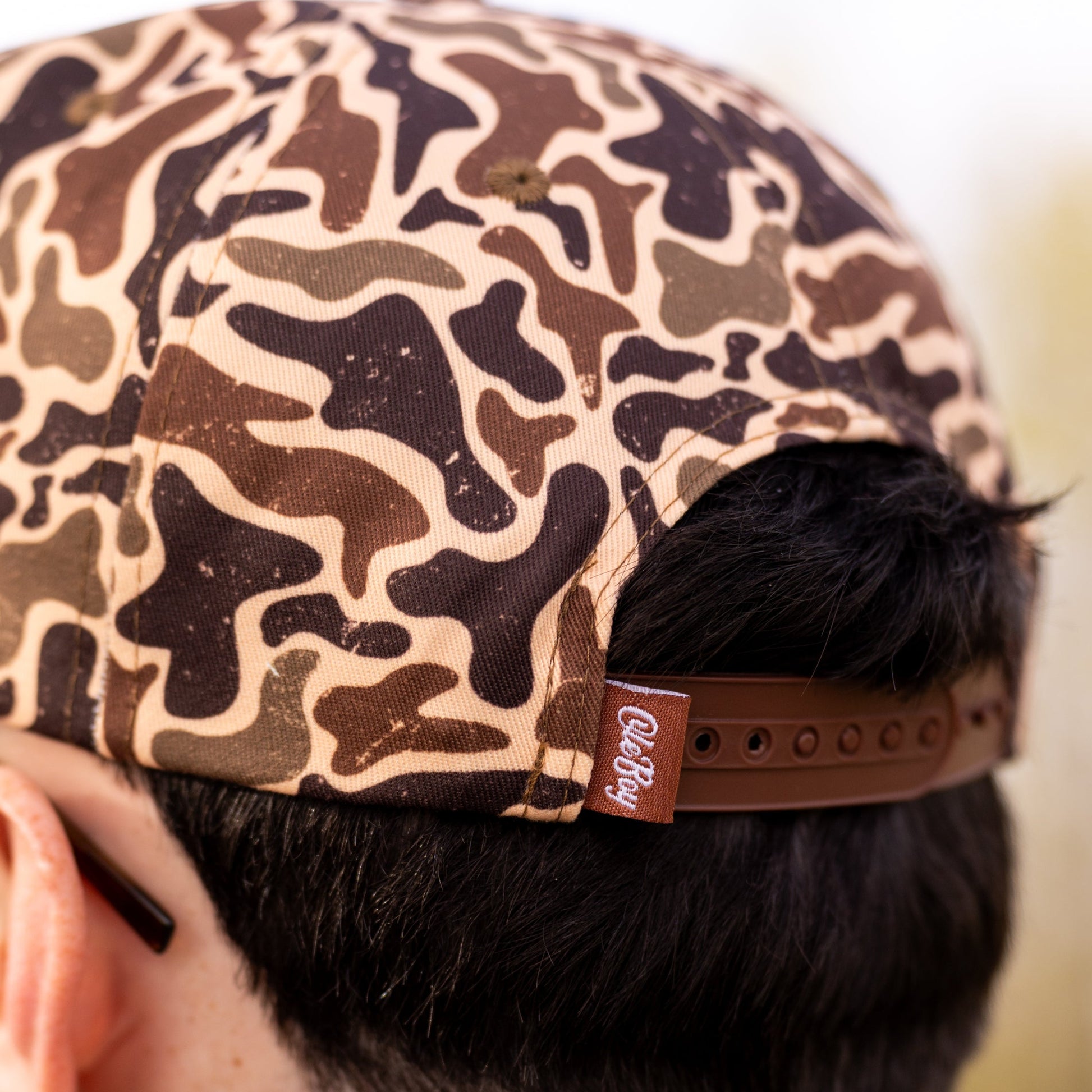 Camouflage-patterned cap worn by a person with a blurred background