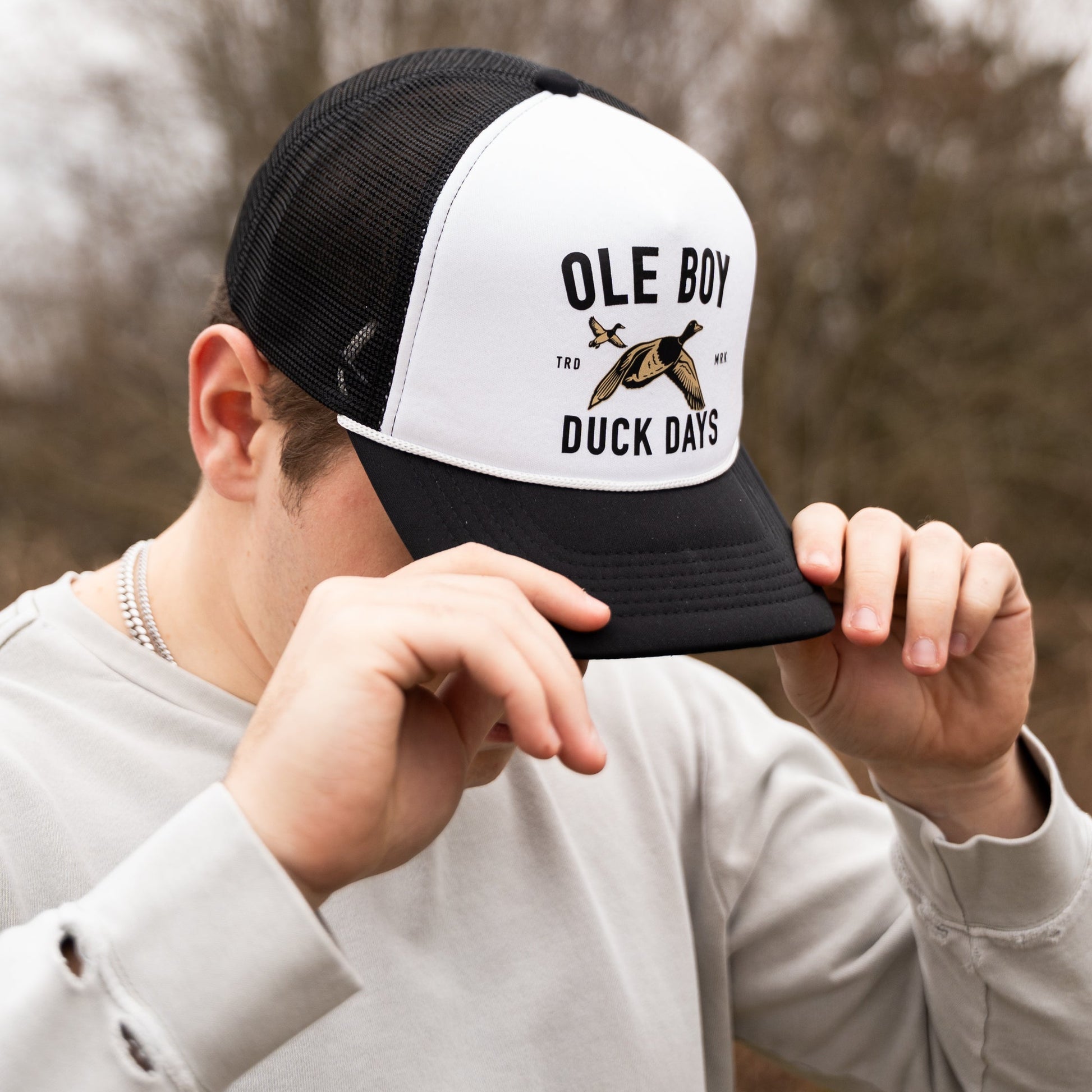 Person wearing a black and white cap with 'Ole Boy' and 'Duck Days' text and logo.