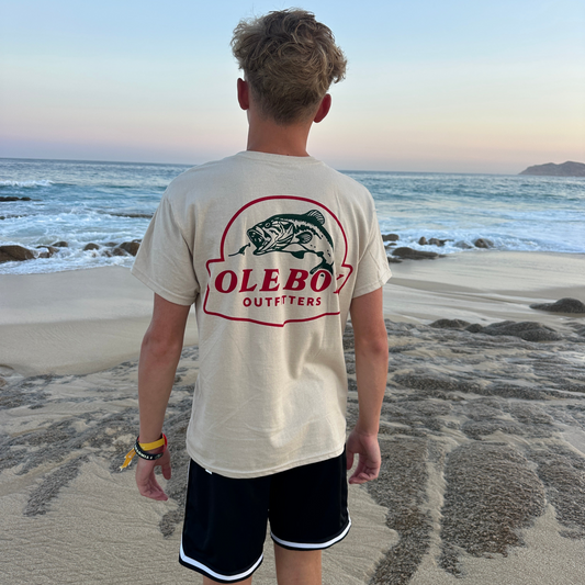 Person wearing an Ole boy t-shirt on a beach