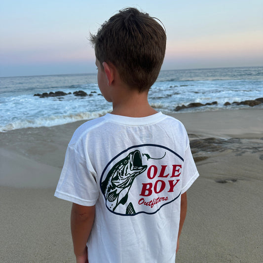 Person wearing a white t-shirt with 'Ole Boy' logo on a beach